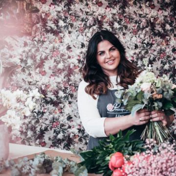 Dame mit Blumenstrauß vor blühendem Strauch - Dienstleister Nähe Graz: Floristik